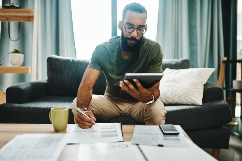 Person reviewing paperwork and a tablet at home