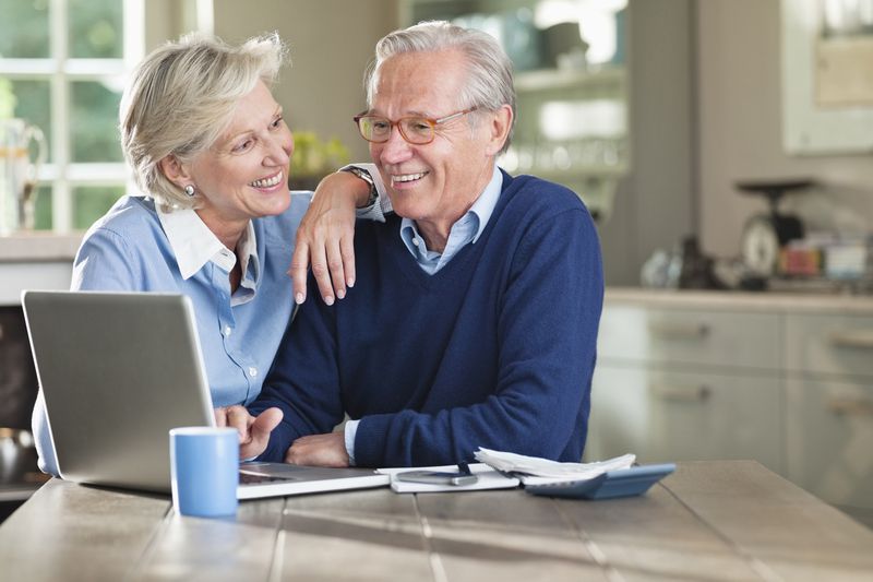 A retired couple using a laptop computer.