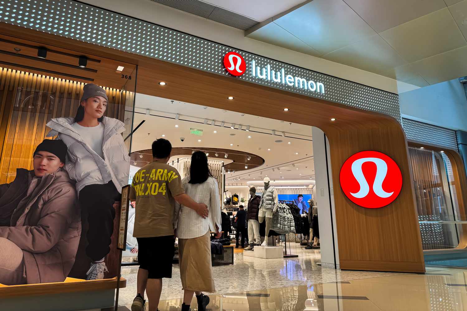  Shoppers walk past a Lululemon store featuring its signature modern design and lifestyle branding on November 16, 2024 in Shenzhen, Guangdong Province, China.