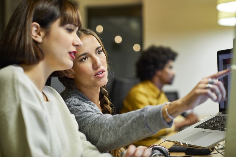 Co-workers Discussing Over Computer in Office