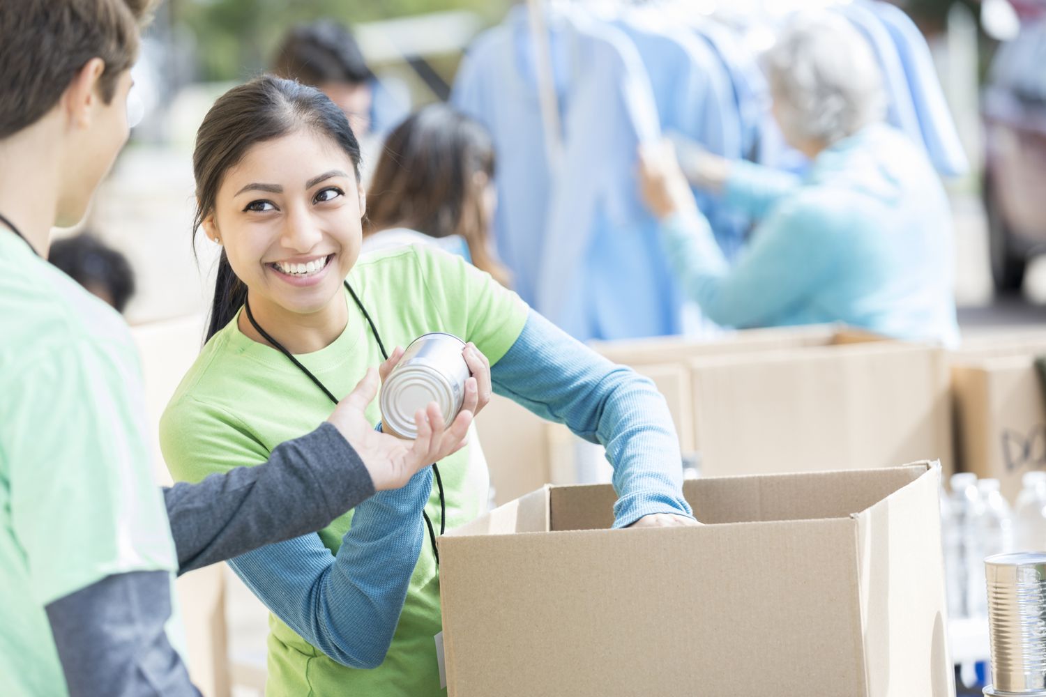 A woman passing out canned goods