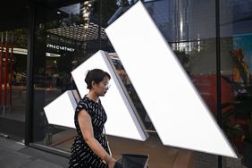 A woman walks past an Adidas store at a mall in Beijing on June 16, 2024
