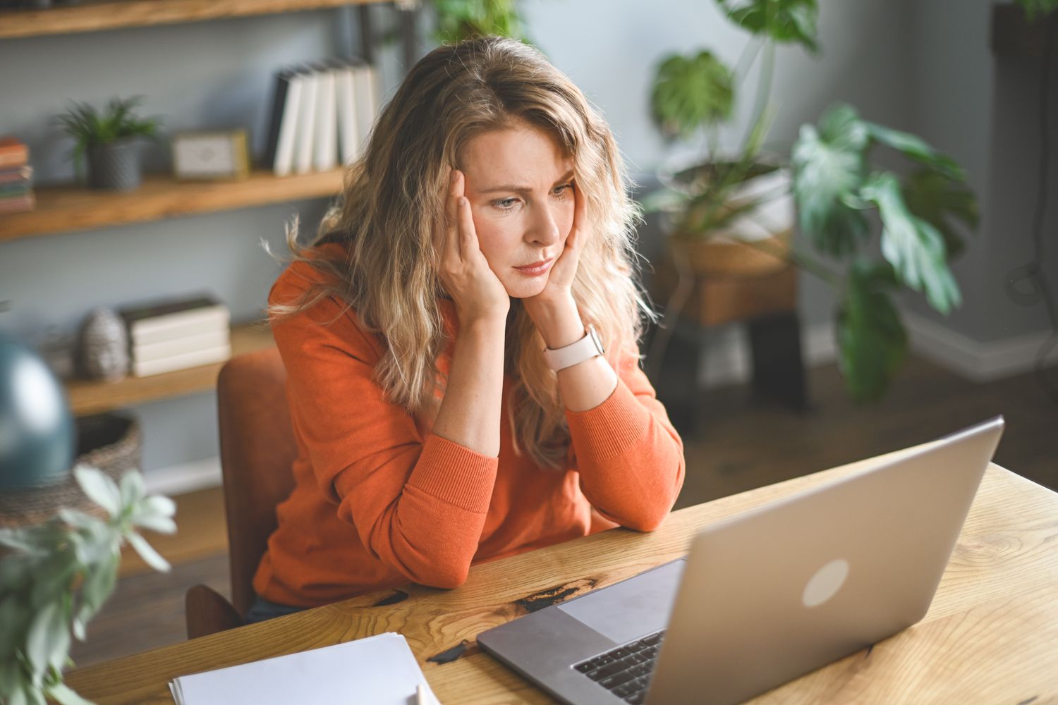 Frustrated woman sitting in front of laptop trying to figure out ways to get a credit card with bad credit.