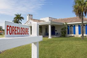 A house with a foreclosure sign out front