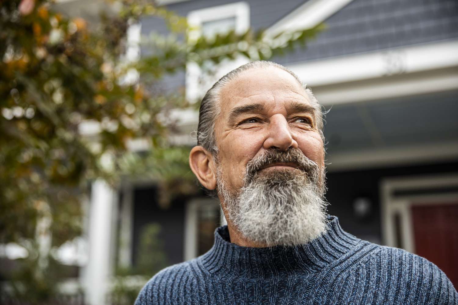 Portrait of senior man in front of suburban home