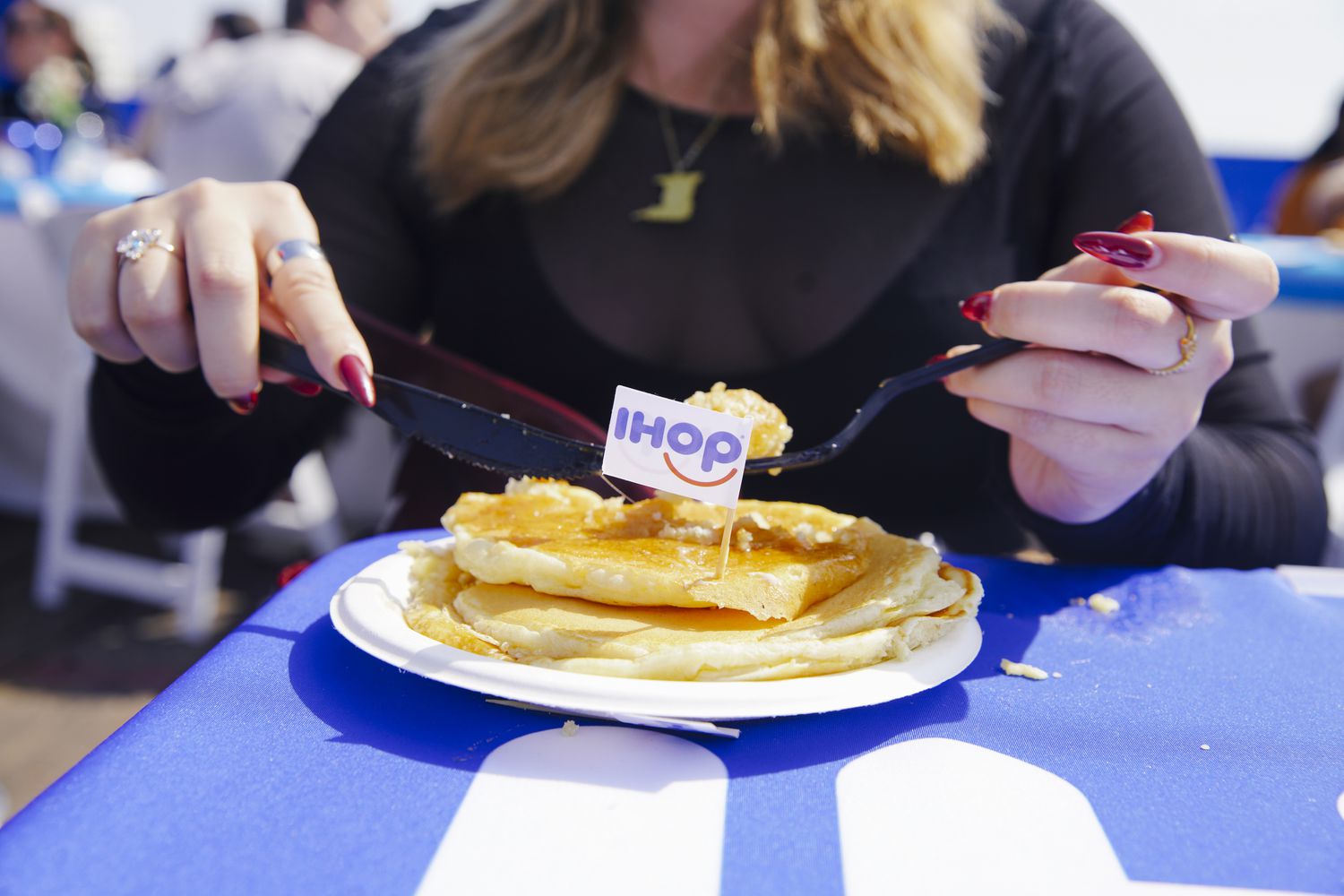 A woman prepares to eat pancakes. 