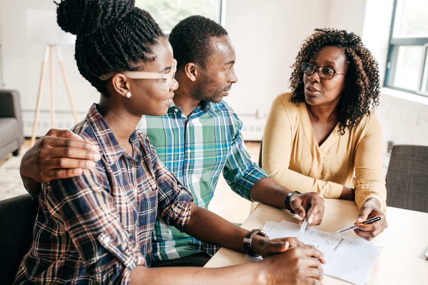Couple talking about personal loan with financial advisor.