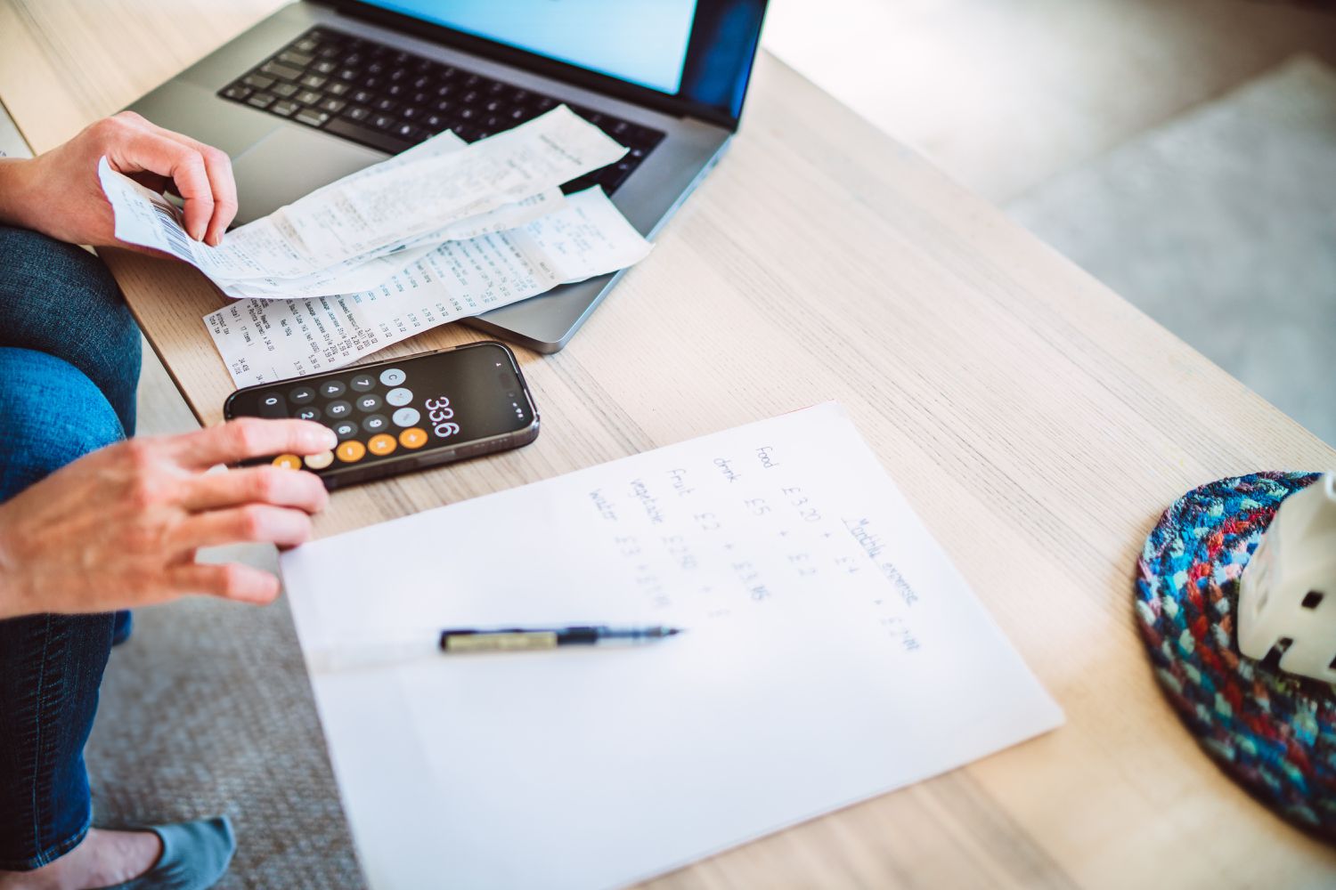 A high angle close-up shot of Close-up of a young woman meticulously managing home finances, demonstrating hands-on budgeting and expense tracking. 