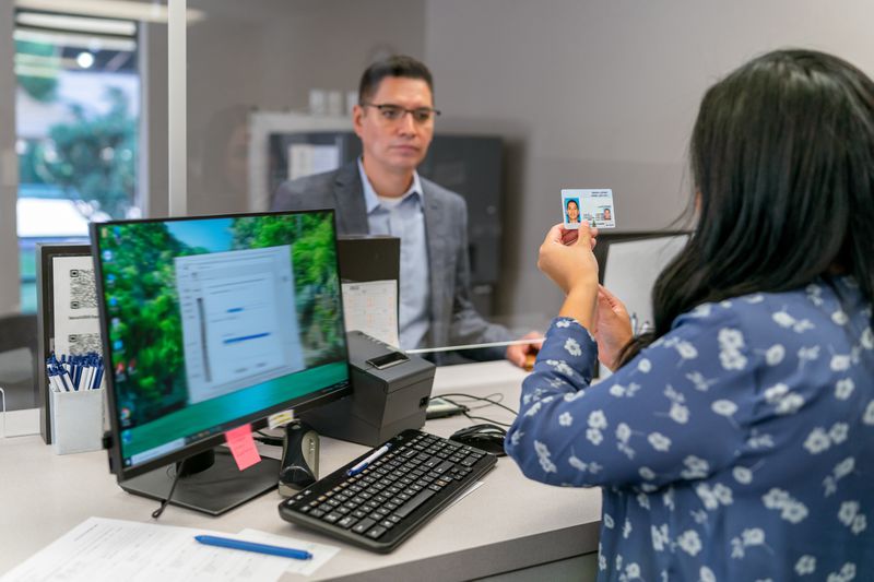 Man being verified by ID while applying for a secured loan at the bank.
