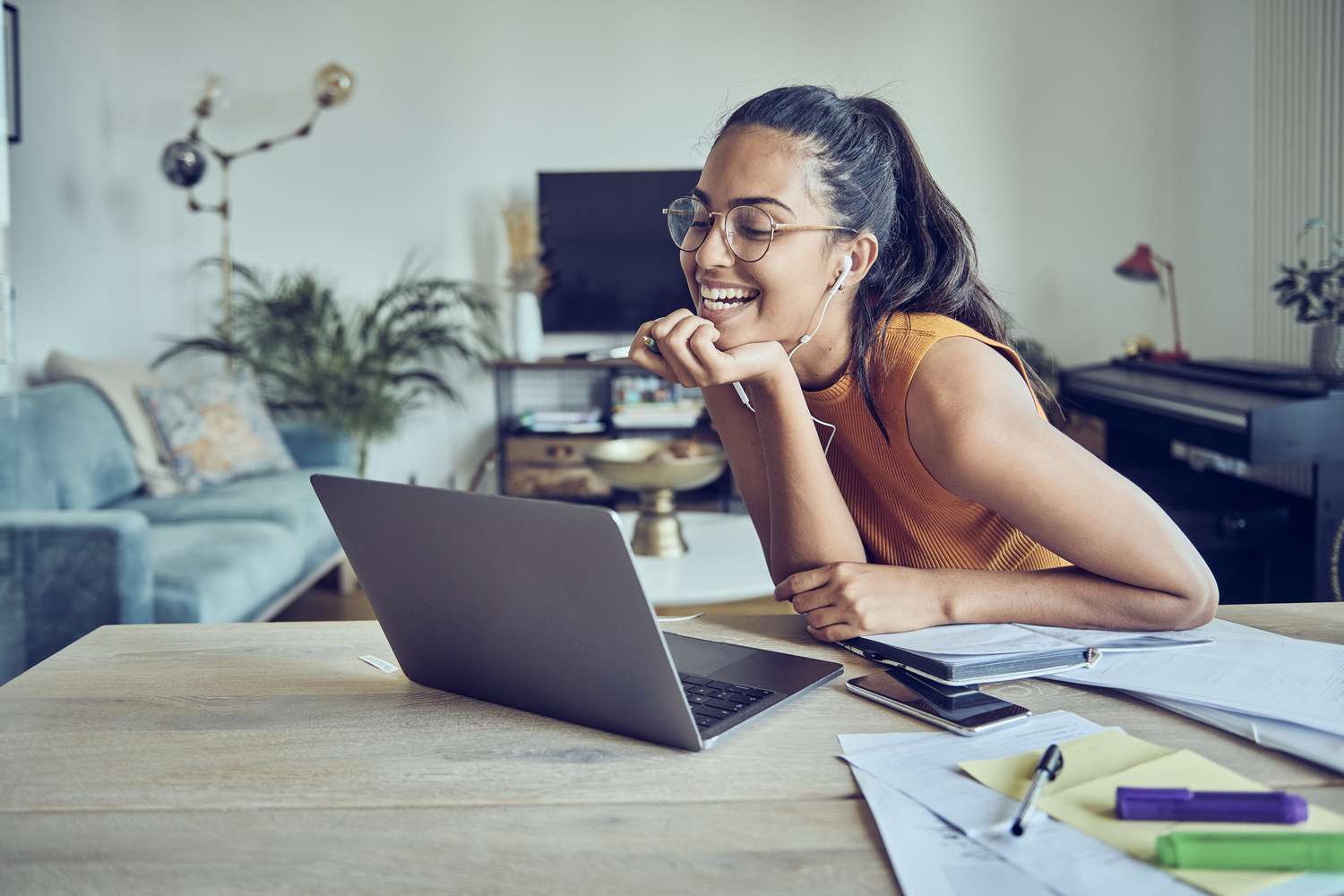Beautiful woman using a mobile phone, laptop while working from home