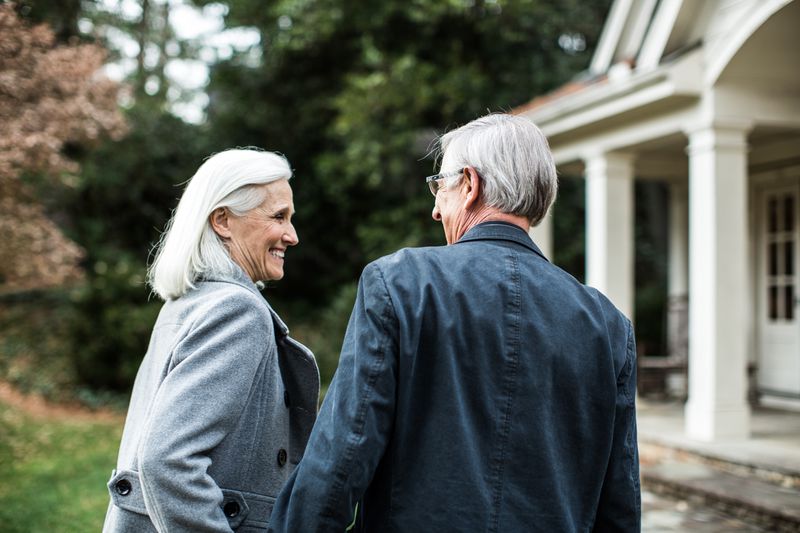 Senior couple in front of house