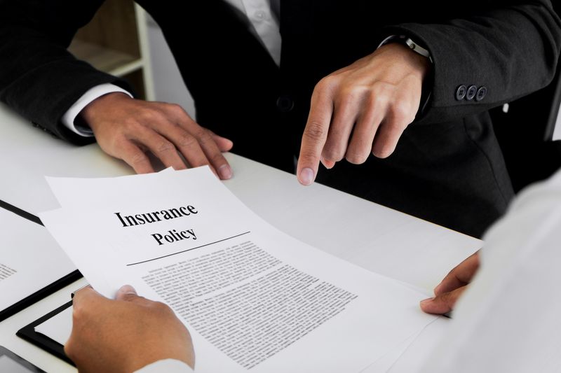 Businessman explaining insurance policy to customer in office.