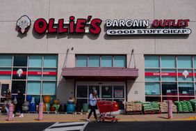 People walk in front of an Ollie's Bargain Outlet store.