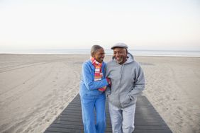 A retired couple walking at the beach
