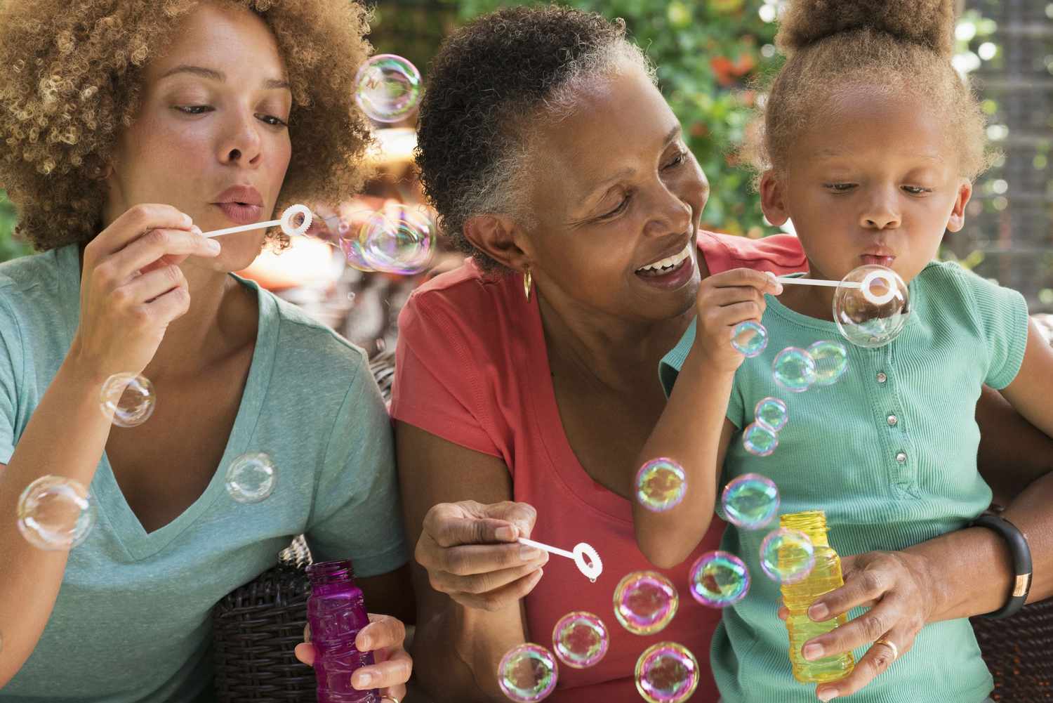 Multigenerational family blowing bubbles outdoors