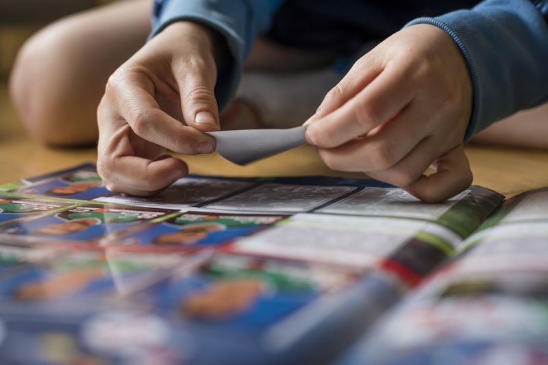 Person pasting sports trading cards in an album
