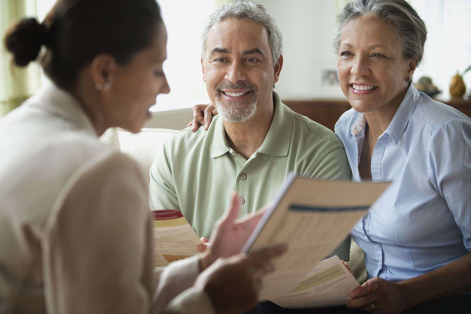 Saleswoman talking to a couple in a living room