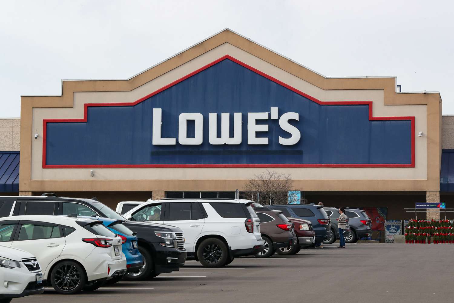 Several cars are parked outside a Lowe's store.