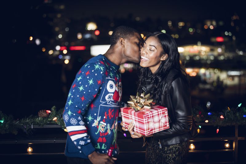 A woman accepting a present and kiss from a male friend