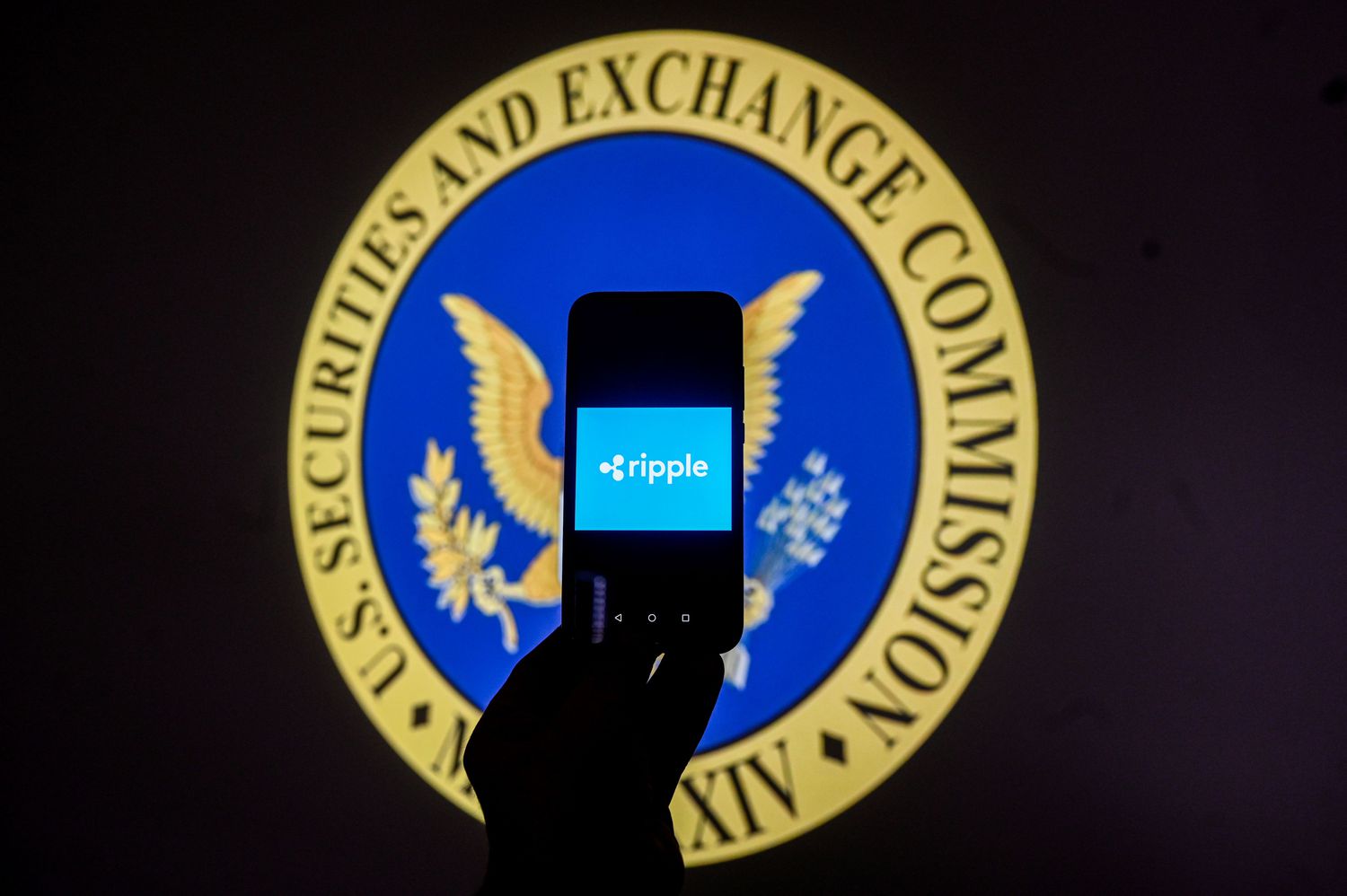 Illustration of the Ripple logo on a smartphone in front of the logo of the Securities and Exchange Commission (SEC)