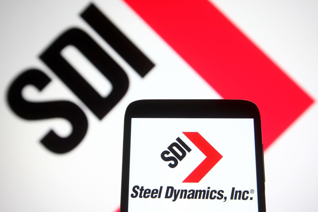In this photo illustration a Steel Dynamics, Inc (SDI) logo is seen on a smartphone and a pc screen.