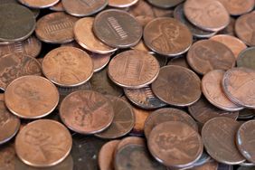 A pile of U.S. pennies seen from overhead, displaying various sides