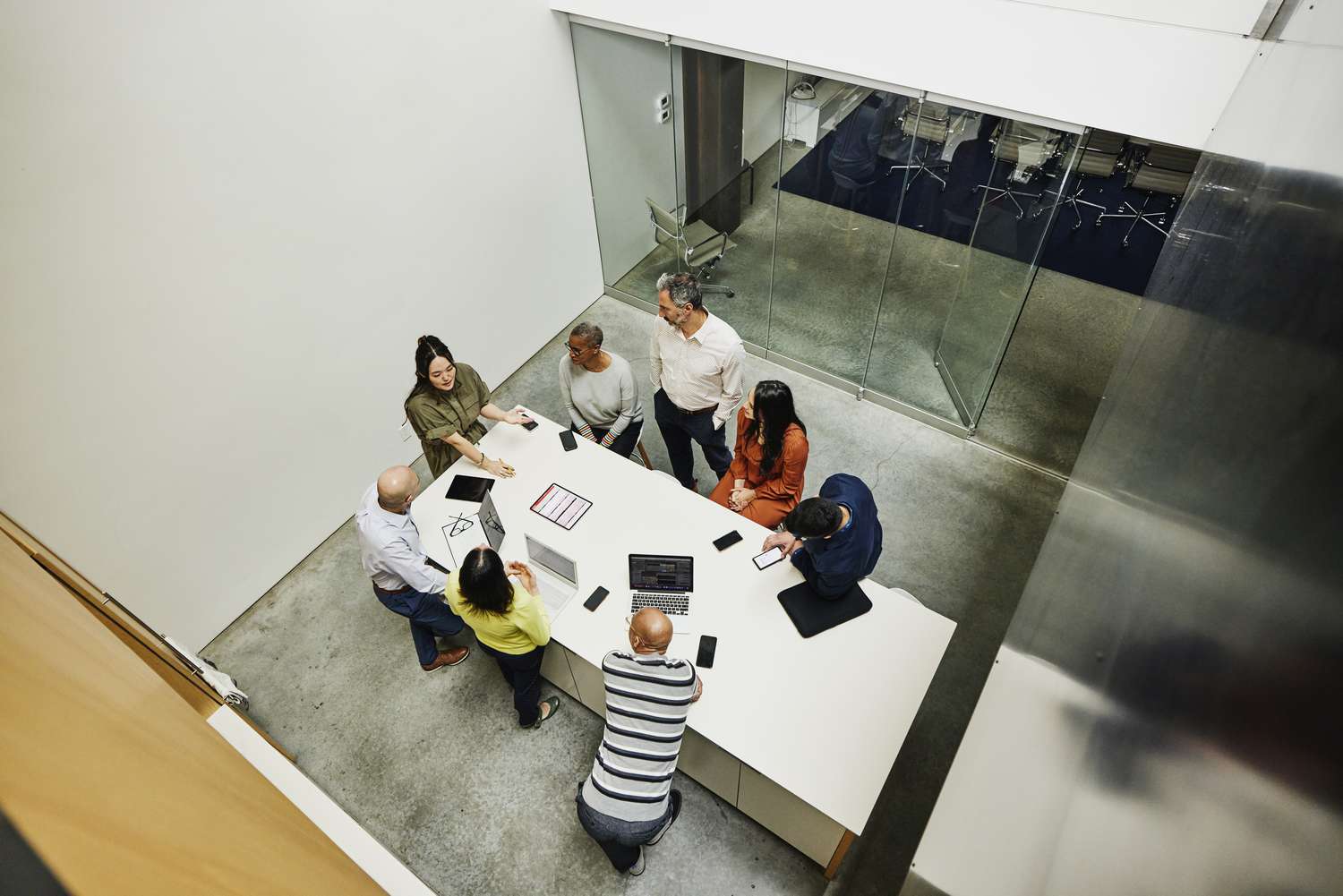 Wide high angle shot of businesswoman leading project meeting at conference table in office