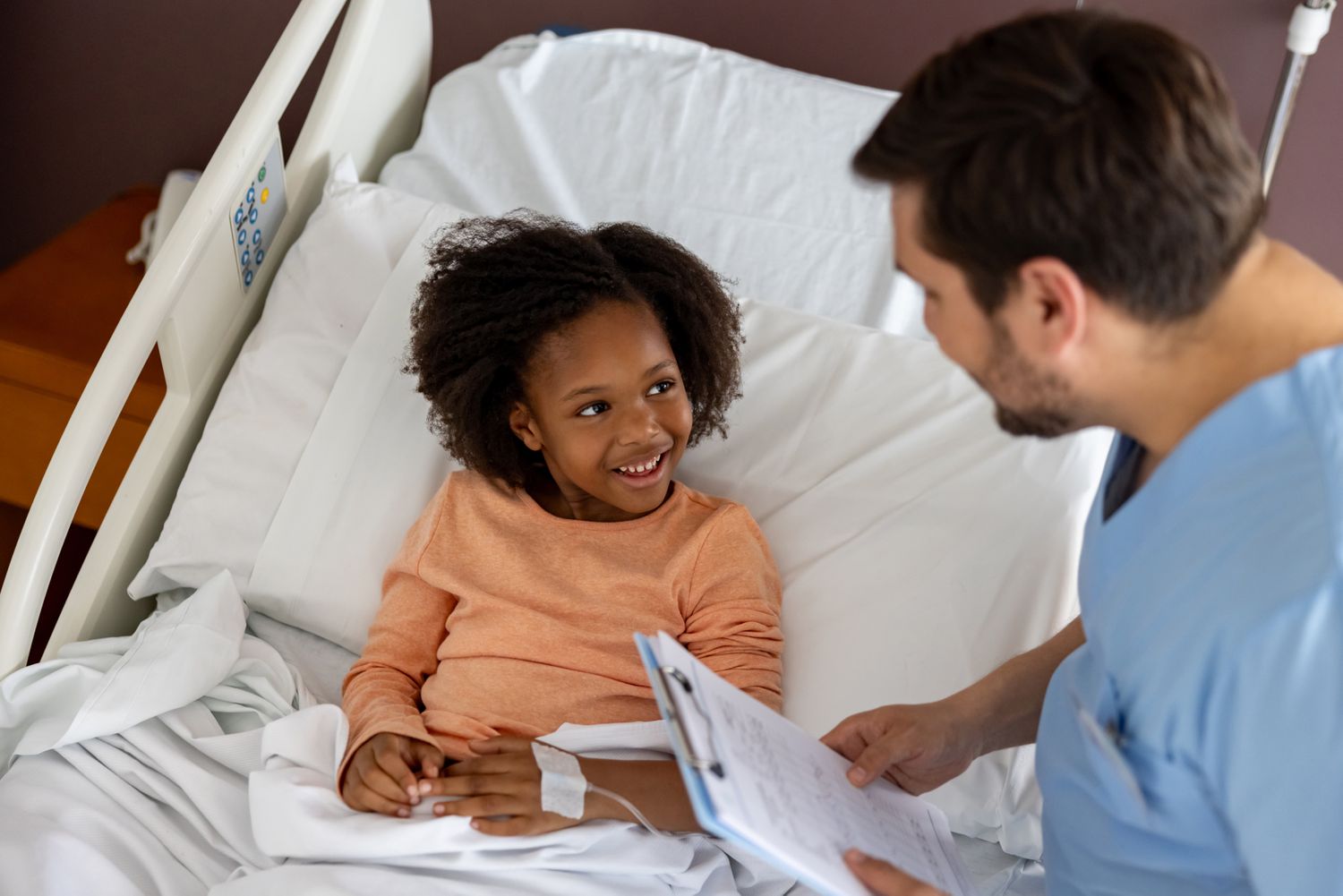 Nurse talking to a child in a hospital bed