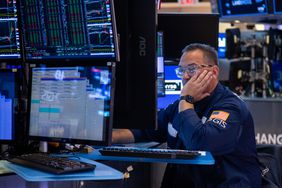 A stock trader on the stock exchange floor watching trades on a computer