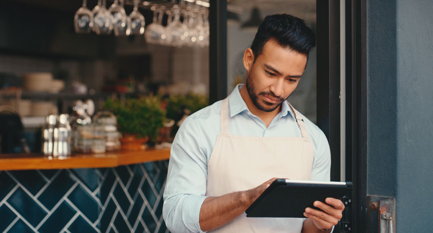 Server in an apron with a digital tablet