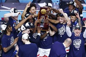 The University of Connecticut Huskies celebrate with the NCAA tournament trophy after winning the 2024 championship.