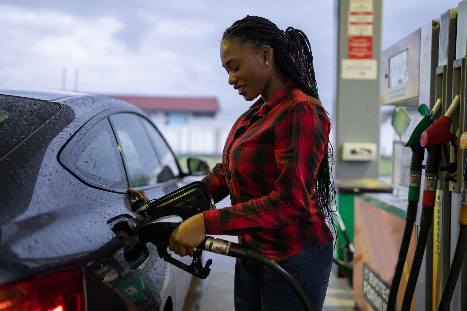 Woman refueling car at a gas station