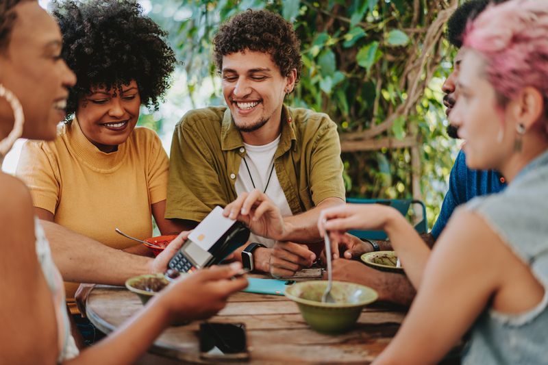 Group of friends contactless payment with credit card