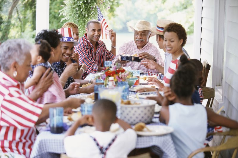 Multigenerational Black family eating at Fourth of July barbecue