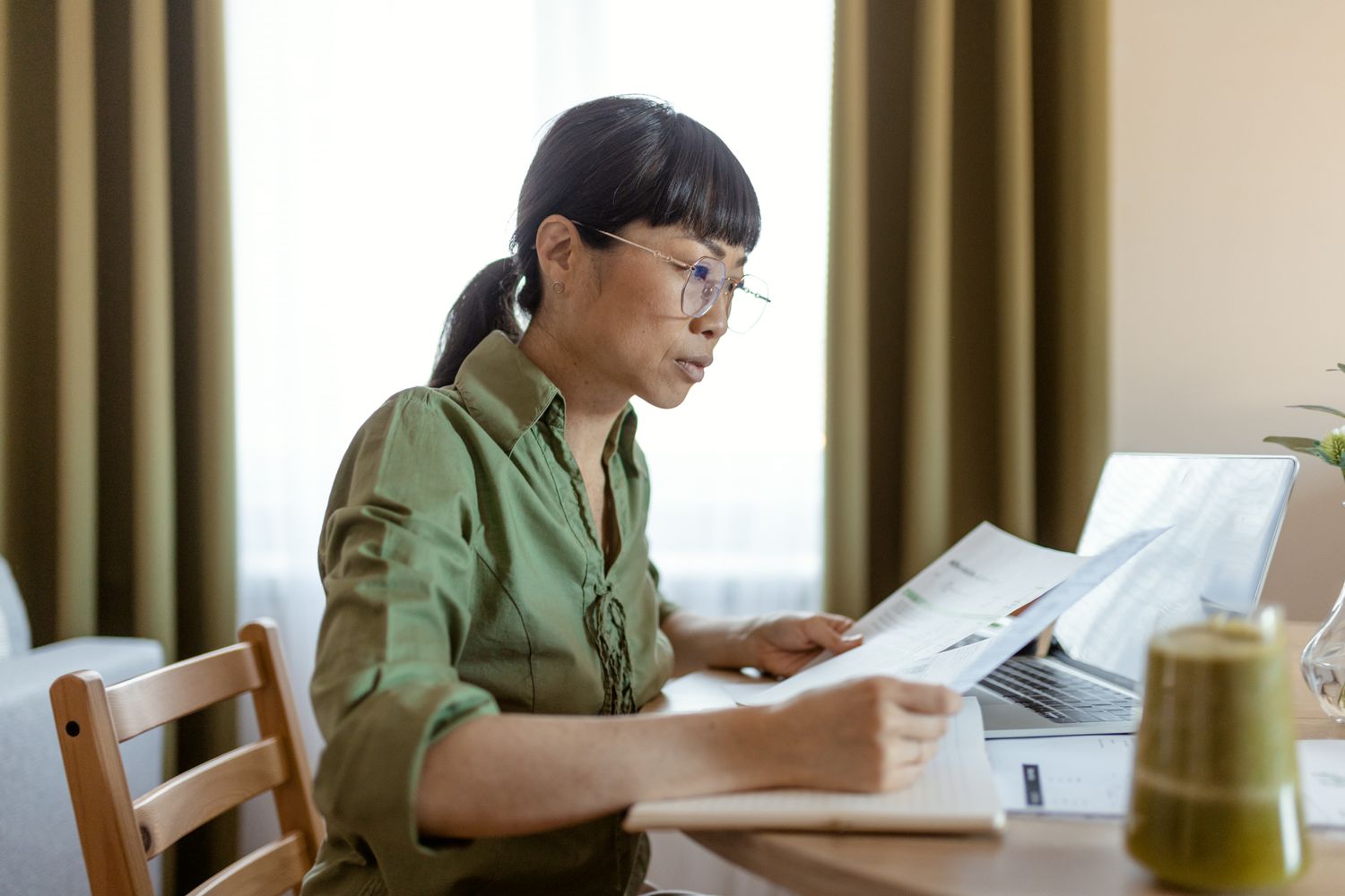 Woman sitting at a table reviewing documents