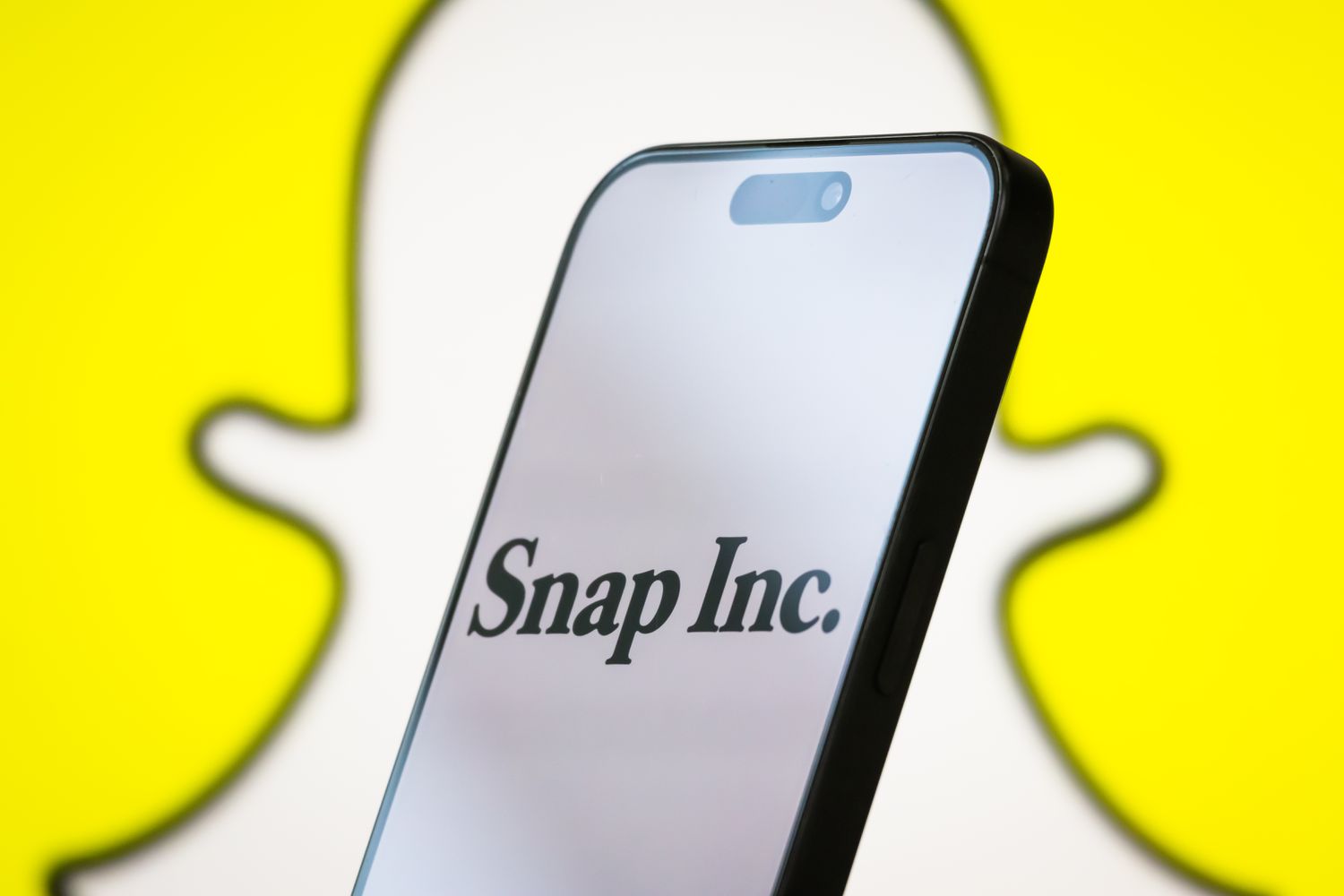 The logo of Snap Inc. is displayed on a smartphone screen, with the company's iconic Snapchat ghost branding visible in the background