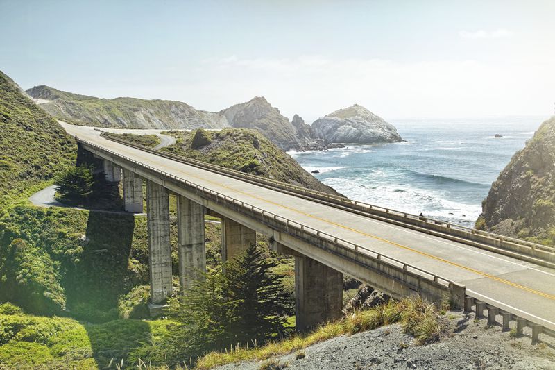 A panoramic view of Big Sur highway in California, showcasing mountains and the ocean.