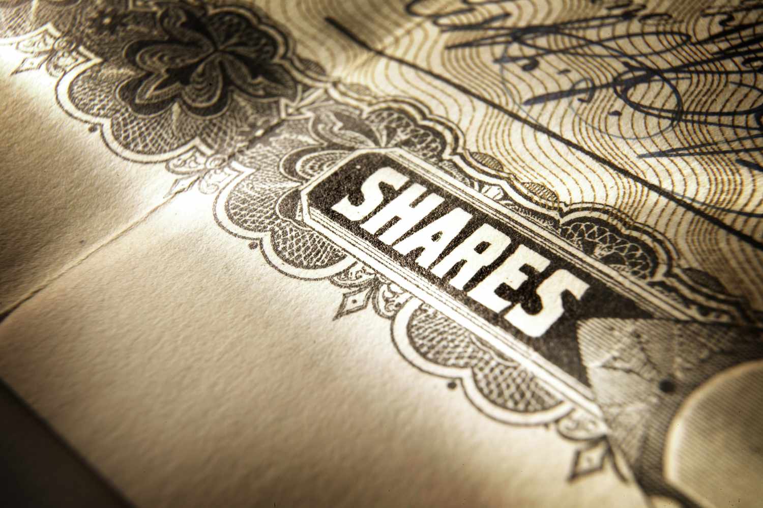 A close-up view of a stock certificate, depicting the word "shares."
