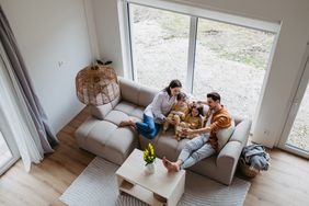 Aerial view of a family of four with two young kids sitting on a sofa.