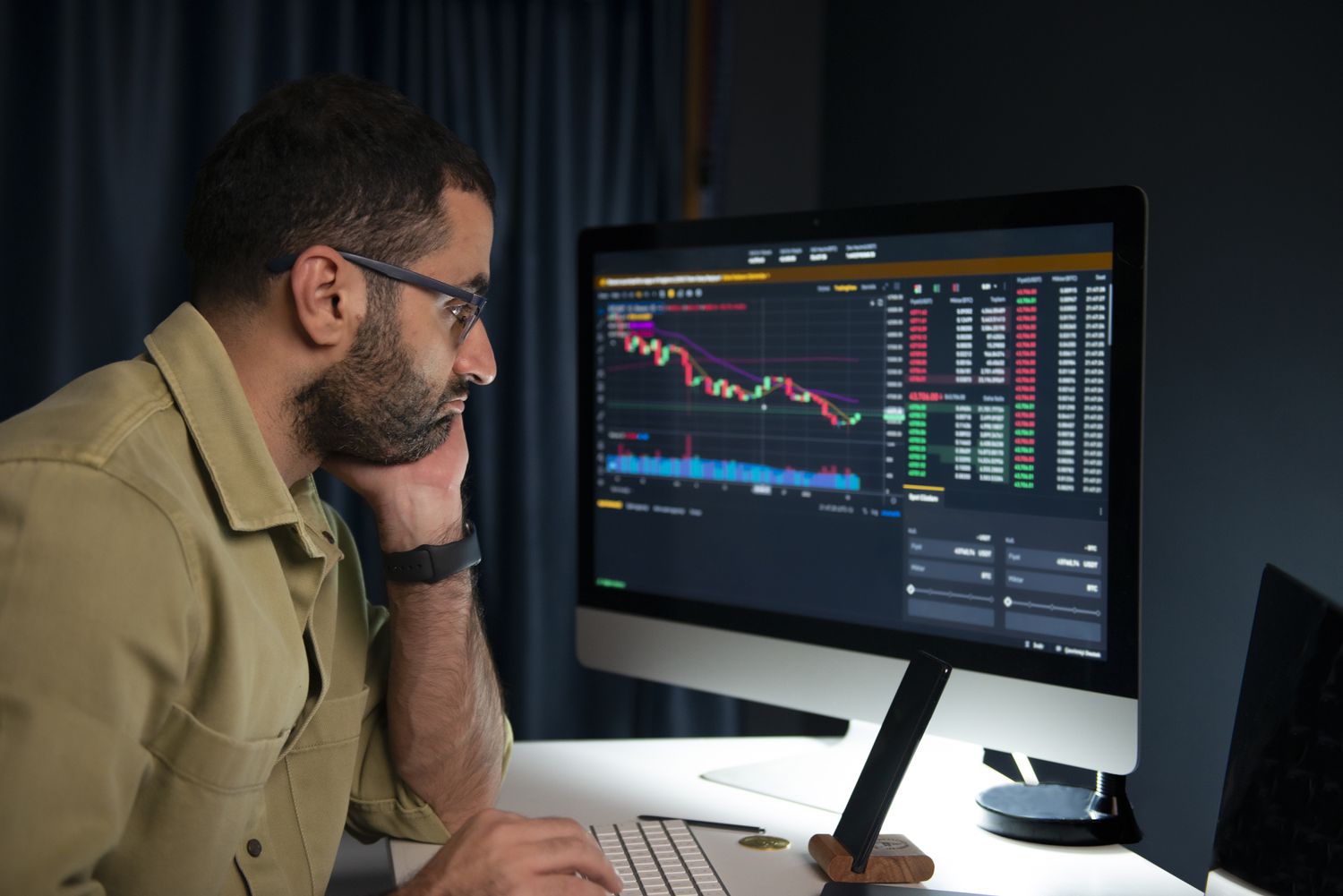 A trader looks at a computer screen analyzing a market trend.