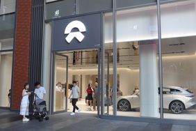 People leave a Nio store in China, with an electric vehicle seen inside the store.