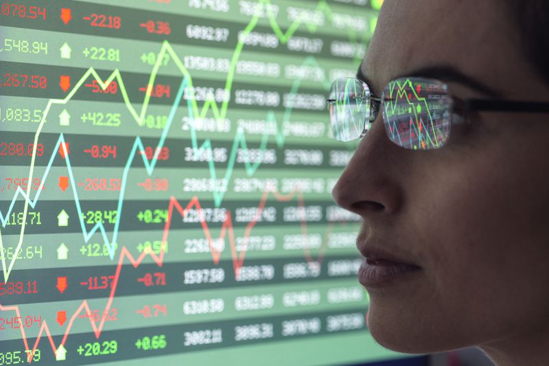 Analyst reviews stock market data on a monitor