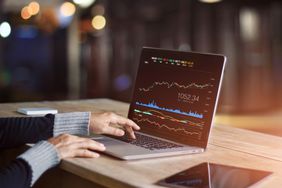 Businessman using laptop for analyzing data stock market, forex trading graph, stock exchange trading online, financial investment concept. All on laptop screen are design up.