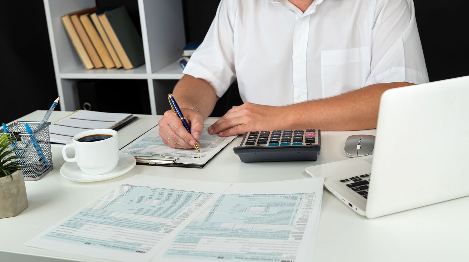 An accountant works at an office desk to complete tax documents for a business.