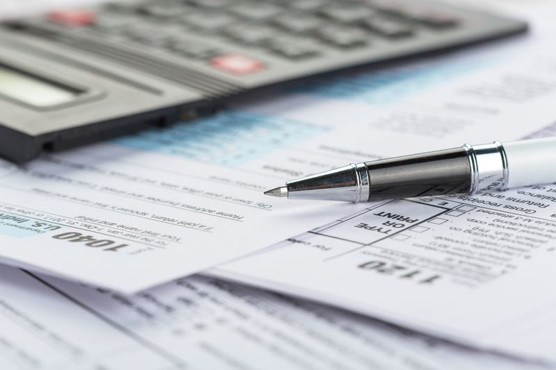 Tax form close ups with calculator and pen