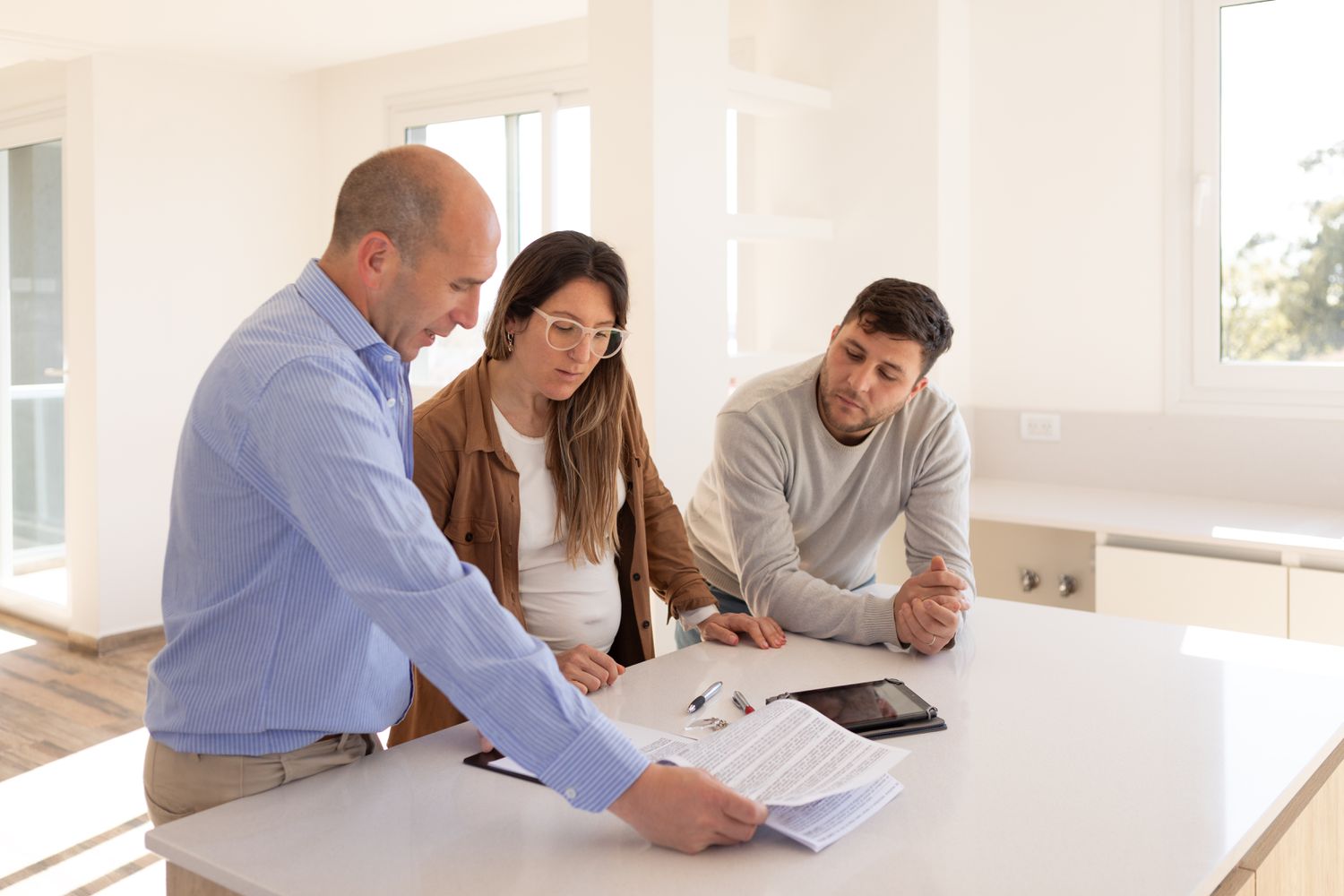 A pair of small business owners read through and sign a lease contract with their landlord for new restaurant property.