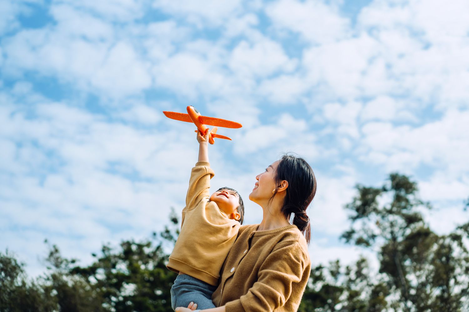 Mother and child with toy airplane outside