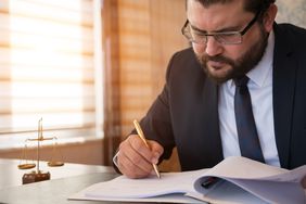A company representative frowns as they sign a waiver of notice document.
