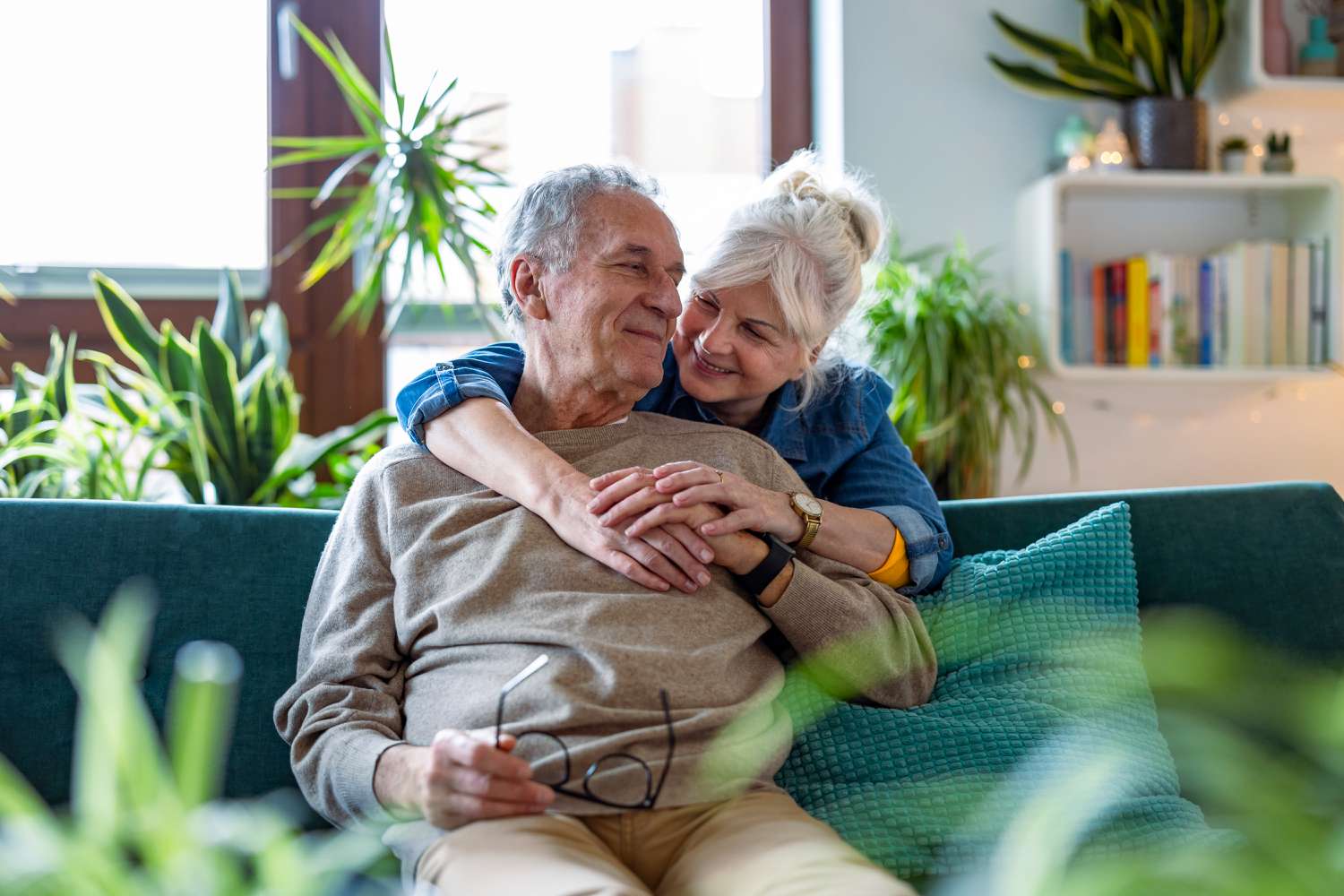 Older couple embracing on a sofa.