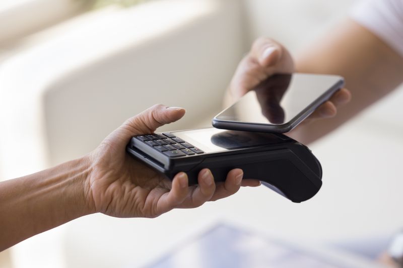 Person making a purchase with a mobile phone.